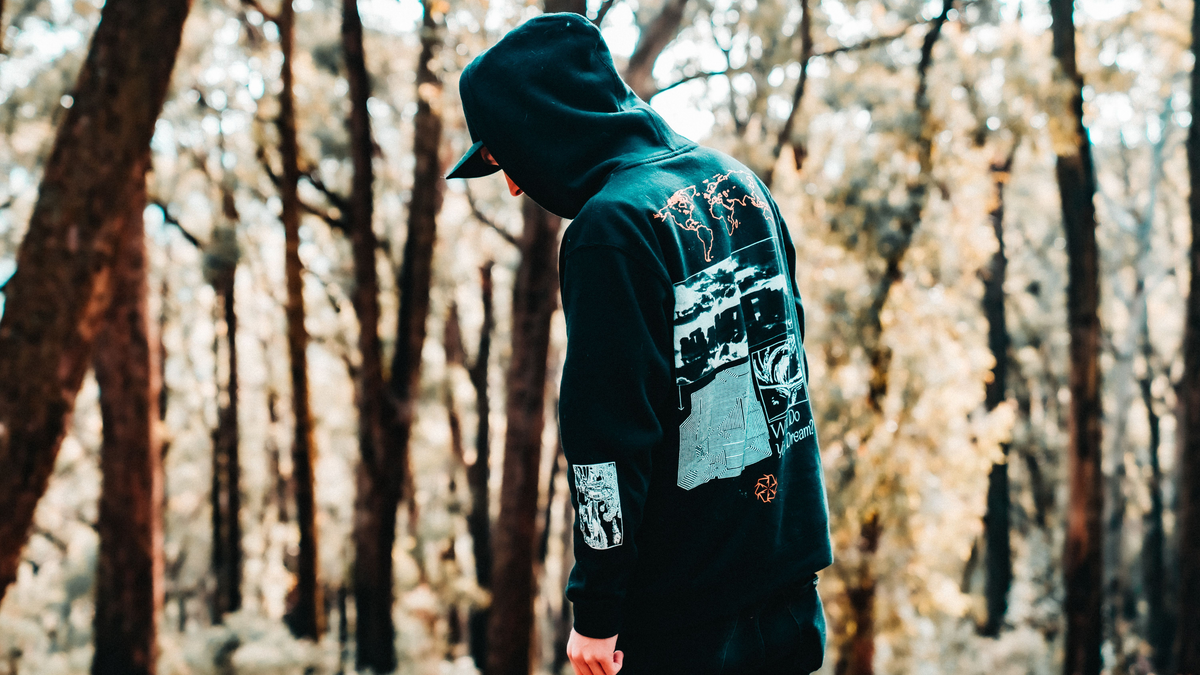 Man wearing a print on demand hoodie in a forest setting
